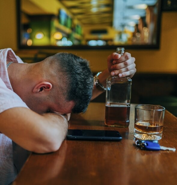 Man drinking in a bar with car keys
