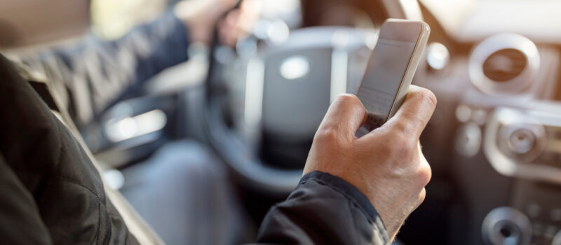 Using a phone in a car texting while driving concept for danger of text message and being distracted