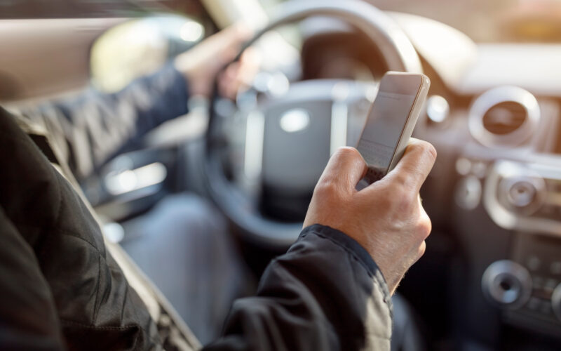Using a phone in a car texting while driving concept for danger of text message and being distracted