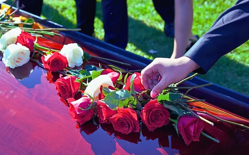 Shot of roses and flowers on top of coffin.