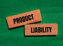 Product liability words written on wooden blocks with green background.