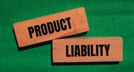 Product liability words written on wooden blocks with green background.
