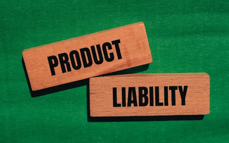 Product liability words written on wooden blocks with green background.