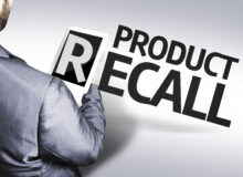 Product recall with a man in suit holding the letter "R" on a tablet device.