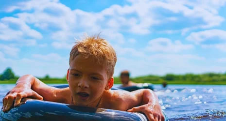 Boy with a rubber ring floats in the summer.