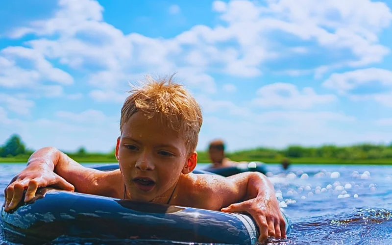 Boy with a rubber ring floats in the summer.