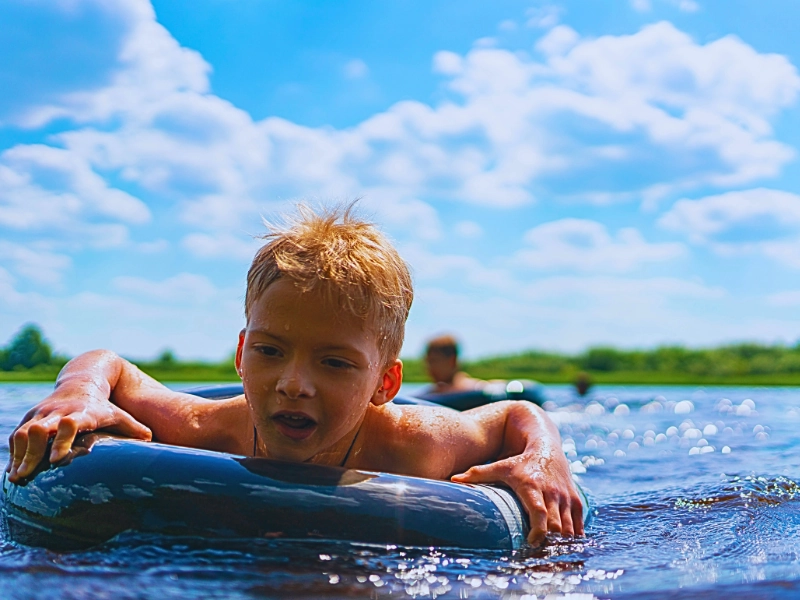 Boy with a rubber ring floats in the summer.