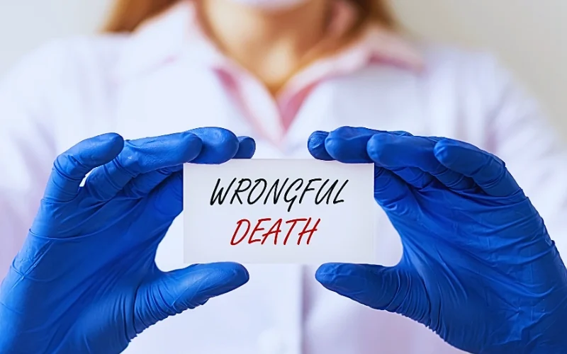 A person wearing blue medical gloves holding a small white card with the words "WRONGFUL DEATH" written on it. How Long Do Families Have to File a Wrongful Death Lawsuit in Florida
