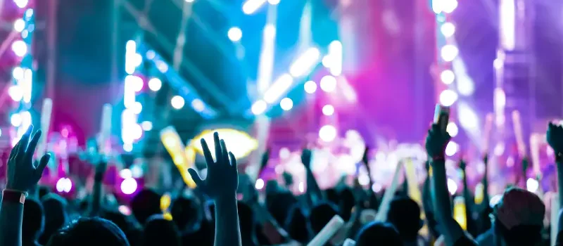 A crowd of people in front of the stage filled with purple and blue lights for a big concert Injuries at Tampa Sporting Events