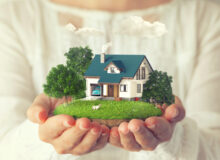 A woman is holding in her hands a house