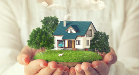 A woman is holding in her hands a house