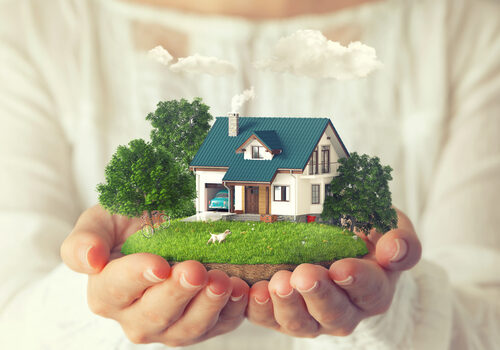 A woman is holding in her hands a house