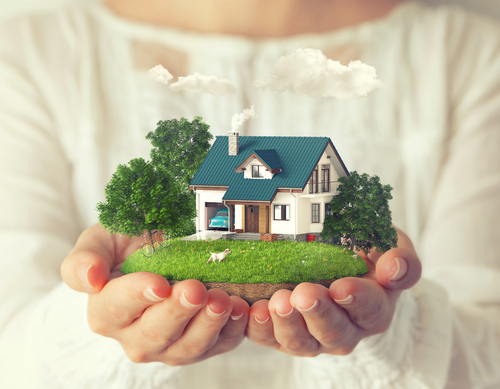 A woman is holding in her hands a house